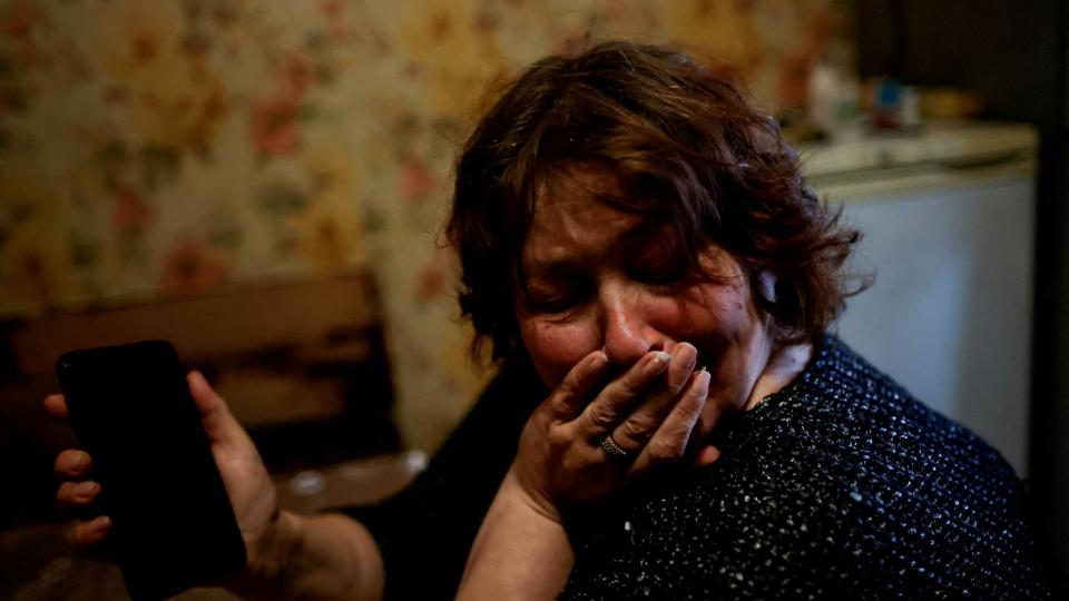 Zhanna Lisjtjynska, der er ukrainer, græder, efter hun har talt i mobiltelefon med sin mand, der befinder sig ved frontlinjen i Zaporizjzja i det østlige Ukraine. <i>Ueslei Marcelino/Reuters</i>