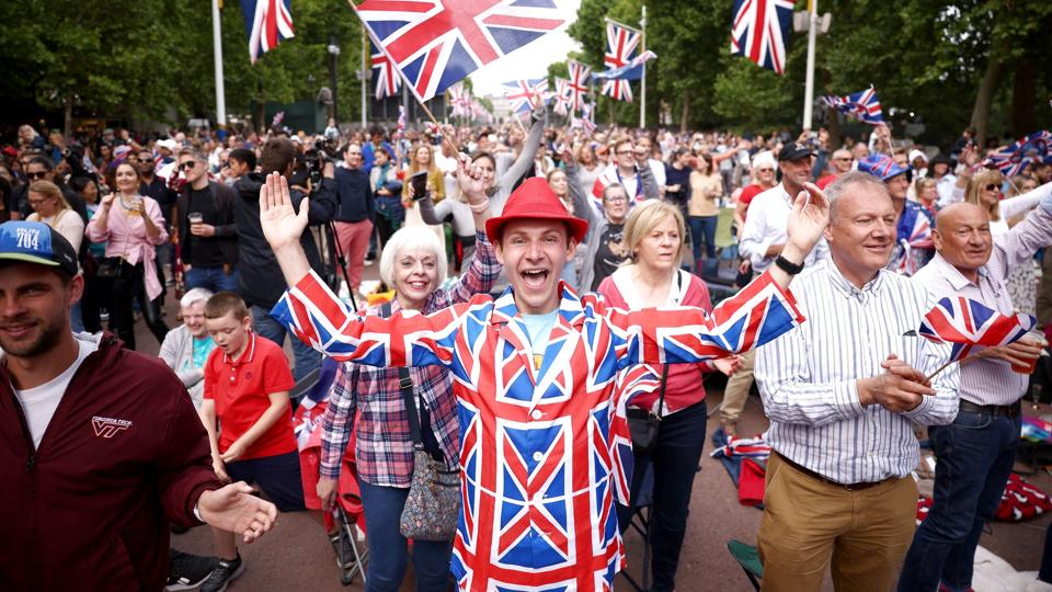 Festglade briter på vej op ad The Mall i London til Buckingham Palace lørdag aften, hvor en stjerneparade af musikere fejrer donning Elizabeth og hendes 70 år på tronen. <i>Henry Nicholls/Reuters</i>