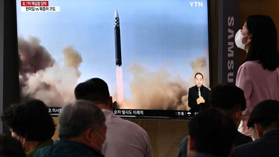 På en togstation i Seoul fulgte ventende passagerer med på tv søndag, da Nordkorea gennemførte en missiltest. <i>Anthony Wallace/Ritzau Scanpix</i>