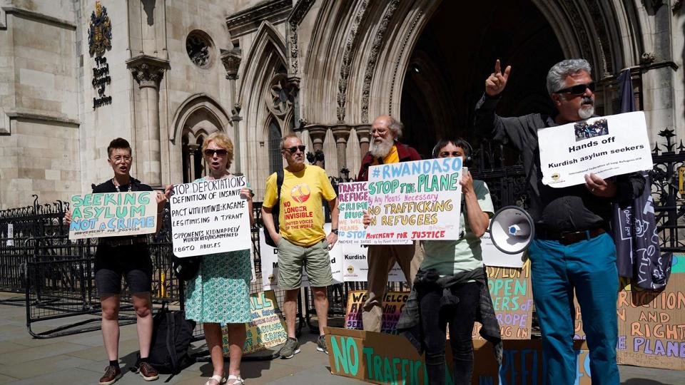 Demonstranter foran den britiske højesteret, hvor de protesterer mod den britiske plan om at sende asylansøgere til Rwanda. Retten tager i dag stilling til planen, herunder om første fly kan sendes afsted tirsdag. <i>Niklas Halle''n/Ritzau Scanpix</i>