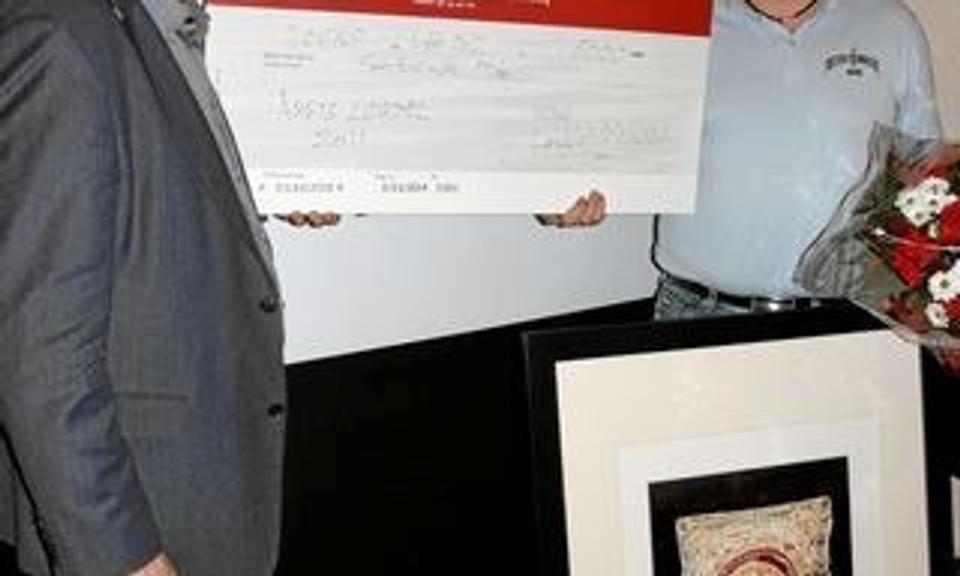 Kulturudvalgsformand Jørgen Pontoppidan (t.v.) overrækker en check på 5000 kroner til "årets ildsjæl" 2012, Carsten Vraa Andersen. Billedkunstneren Peninna Risgaard har udført maleriet. Privatfoto