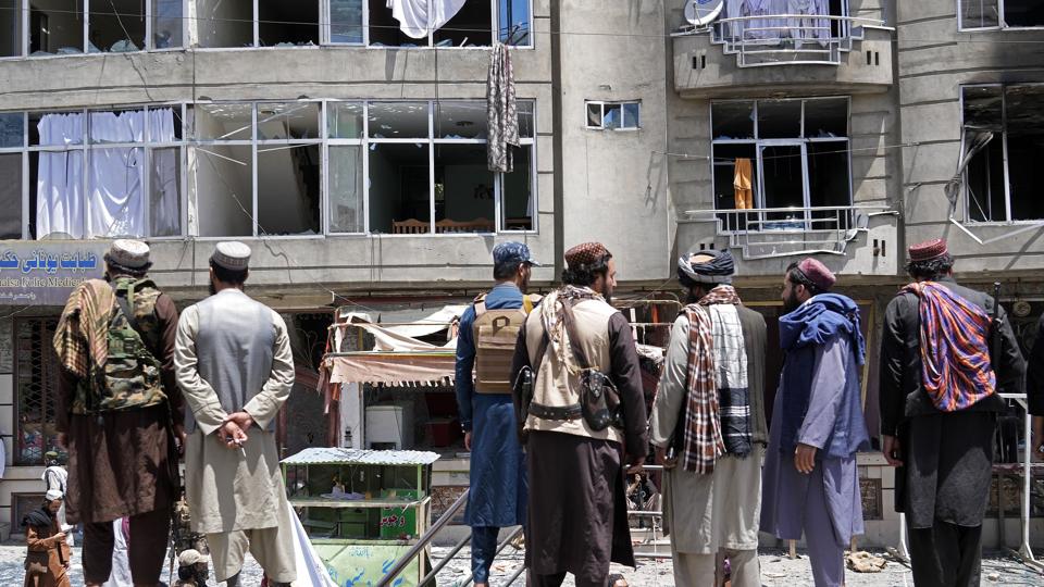 Folk fra Taliban ses her foran sikh-templet, der lørdag blev angrebet i Kabul. <i>Ebrahim Noroozi/Ritzau Scanpix</i>