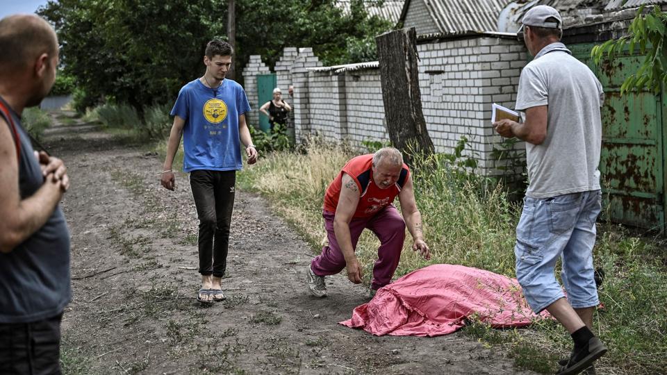 En mand går hen mod sin søn, som angiveligt blev dræbt af en raket med en klyngebombe i byen Lysytsjansk, som er tvillingeby Sjevjerodonetsk ved floden Siverskyj Donets. <i>Aris Messinis/Ritzau Scanpix</i>
