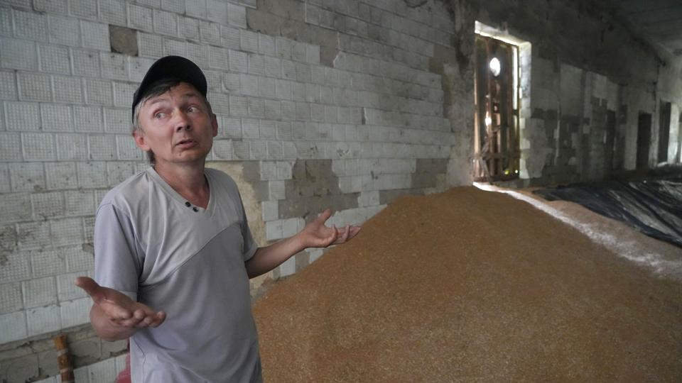 En ukrainsk landmand ses her i sidste uge foran en bunke korn, som han - ligesom mange andre - ikke har kunnet eksportere på grund af Ruslands kornblokade. <i>Efrem Lukatsky/Ritzau Scanpix</i>