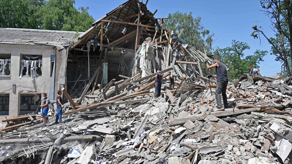 Oprydning i ruinerne af en ødelagtregeringsbygning iKharkiv-regionen. I det østlige Ukraine ventes en større russisk offensiv før og under EU's topmøde torsdag og fredag. <i>Sergey Bobok/Ritzau Scanpix</i>