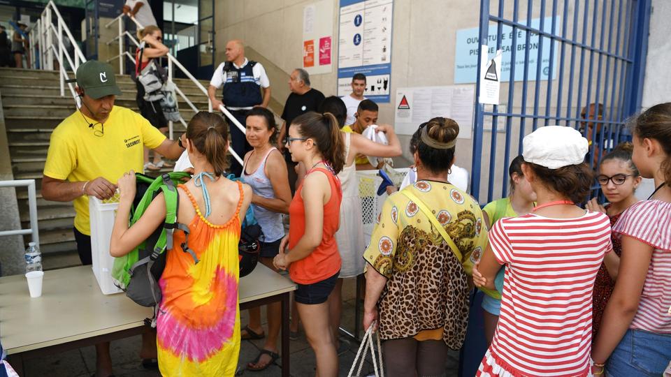 Brugen af den såkaldte burkini har tidligere været forbudt i Grenoble og det øvrige Frankrig. I maj tillod Grenobles byråd, at muslimske kvinder måtte bade i burkini - men det er nu omgjort af Frankrigs øverste administrative domstol. Billedet er fra juni 2019, hvor besøgende ved et svømmebad i Grenoble fik tjekket deres tasker for at sikre, at de ikke havde en burkini med ind. <i>Jean-Pierre Clatot/Ritzau Scanpix</i>