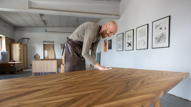 Håndværket og kærligheden til træ driver Klaus Grønning. Her med et spisebord lavet af gulvet fra en sportshal. <i>Foto: Kim Dahl Hansen</i>