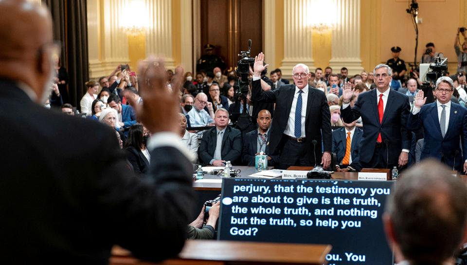 Udvalgsformand Bennie Thompson (med ryggen til) tager Rusty Bowers (til venstre), Brad Raffensperger (i midten) og Gabriel Sterling (til højre) i ed inden tirsdagens høring. <i>Pool/Reuters</i>