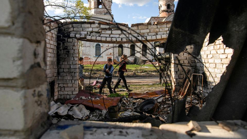 Drenge leger foran en ødelagt kirke i Tjernihiv-regionen. (Arkivfoto). <i>Stringer/Reuters</i>