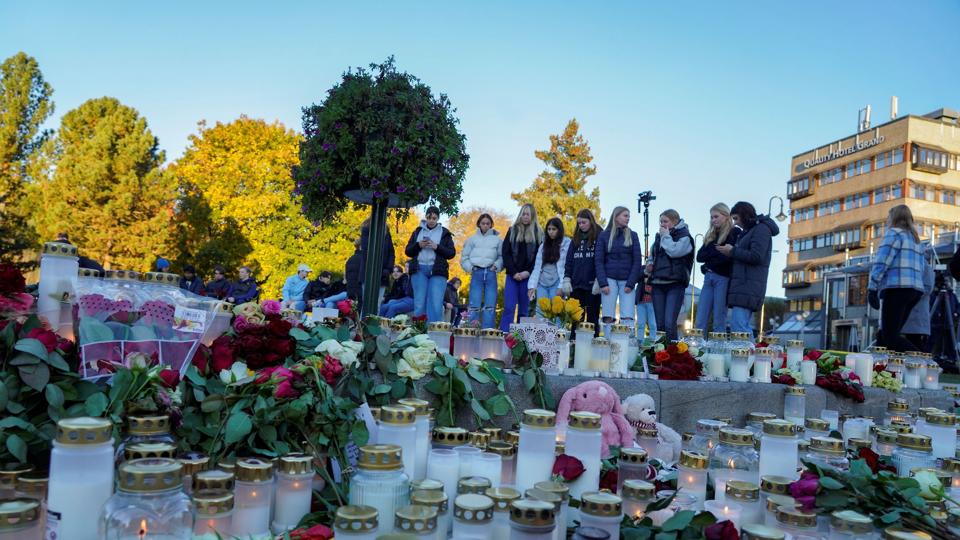 Folk lægger lys og blomster ved et mindesmærke i Kongsberg et par dage efter angreb. <i>Ntb/Reuters</i>