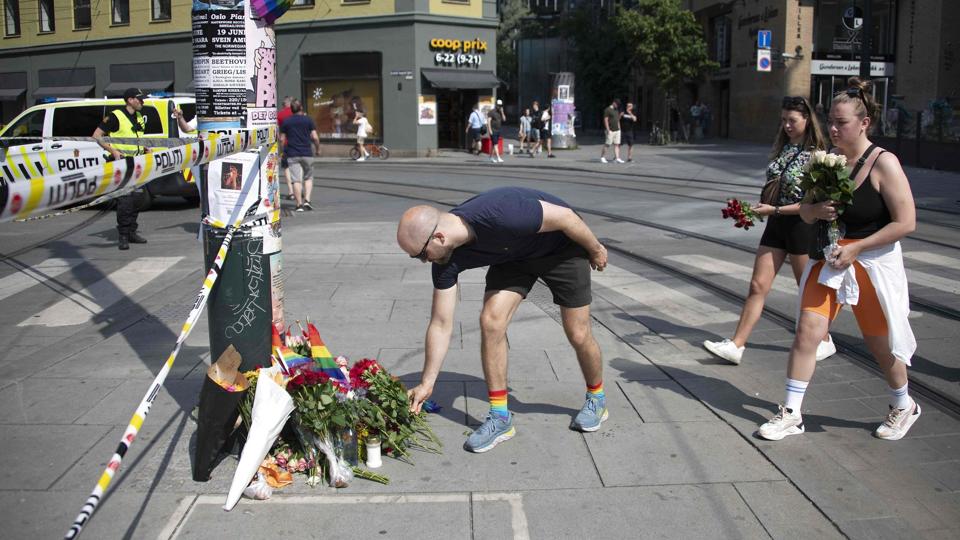 Folk lægger blomster og sætter regnbueflag ved det sted i det centrale Oslo, hvor to mennesker blev dræbt og 21 såret i et masseskyderi natten til lørdag. Politiet efterforsker sagen som terror og ser desuden på, om had kan have været et motiv for gerningsmanden. <i>Olivier Morin/Ritzau Scanpix</i>