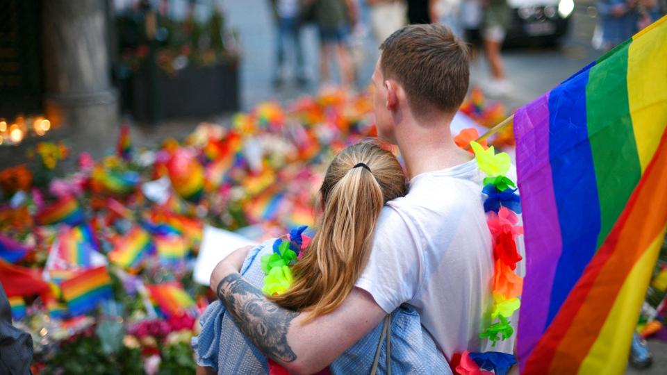 Regnbueflag og blomster præger det sted i det centrale Oslo, hvor to mænd blev dræbt og 21 andre såret i et masseskyderi natten til lørdag. Skyderiet ramte blandt andet en af Oslos mest kendte barer for LGBT-personer. <i>Martin Solhaug Standal/Ritzau Scanpix</i>