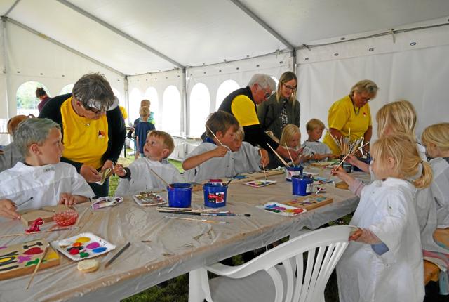 I aktivitetsteltet og omkring på græsplænen finder man frivillige i gule trøjer, der hjælper til på dagen. Privatfoto