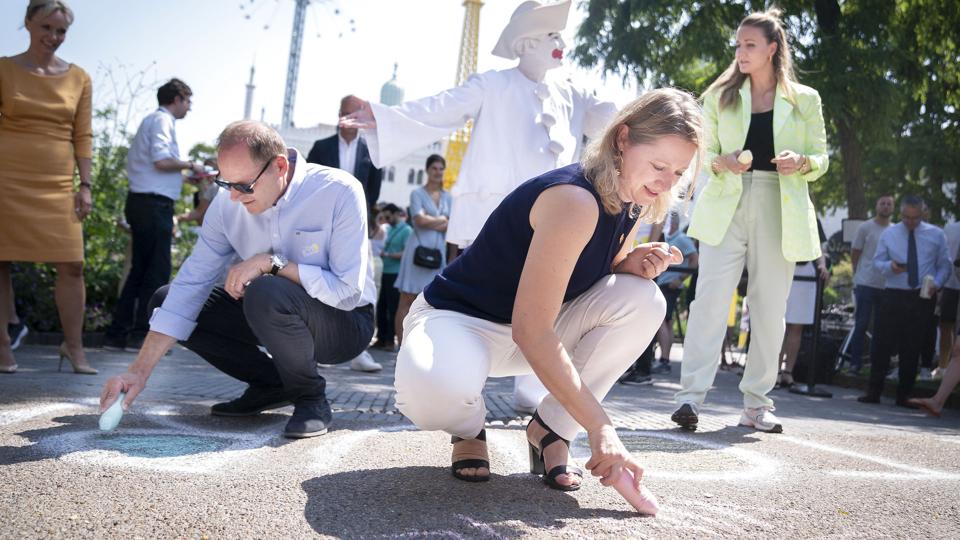 I bedste Tour de France-stil tegnede overborgmester Sophie Hæstop Andersen og løbsdirektør Christian Prudhomme med kridt på asfalten i Tivoli på mandagens pressemøde. Overborgmesteren skrev "Vingegaard". <i>Liselotte Sabroe/Ritzau Scanpix</i>