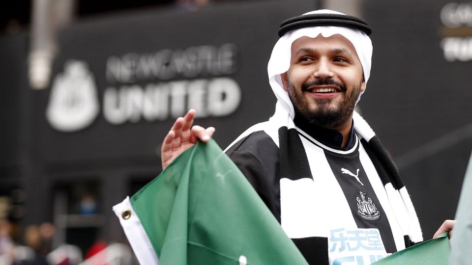 En Newcastle-fan med et saudiarabisk flag har været et hyppigt syn til holdets kampe i den forgangne sæson. Det skyldes, at et saudiarabisk konsortium købte Premier League-klubben tilbage i oktober. Købet er et eksempel på sportswashing, mener to kritikere. <i>Lee Smith/Ritzau Scanpix</i>