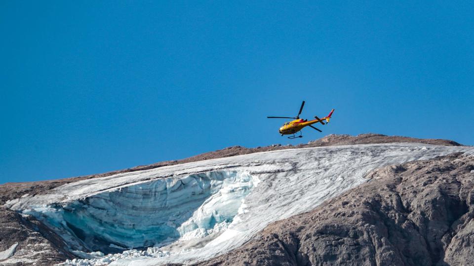 En redningshelikopter flyver mandag over en kollapset gletsjer i Italien. <i>Pierre Teyssot/Ritzau Scanpix</i>