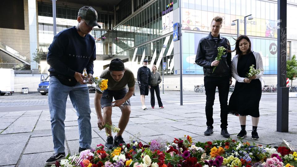 Forbipasserende lægger blomster og tænder lys ved butikscentret Field's på Amager, hvor tre personer søndag mistede livet i et skyderi. <i>Philip Davali/Ritzau Scanpix</i>