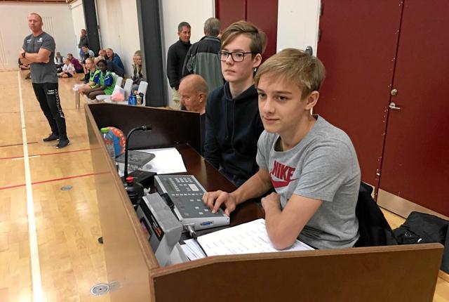 Asger Leerskov (forret) og skolekammeraten Nemo Peters der sidder ved dommerbordet i kampen mellem Hadsten og Dronninglund.