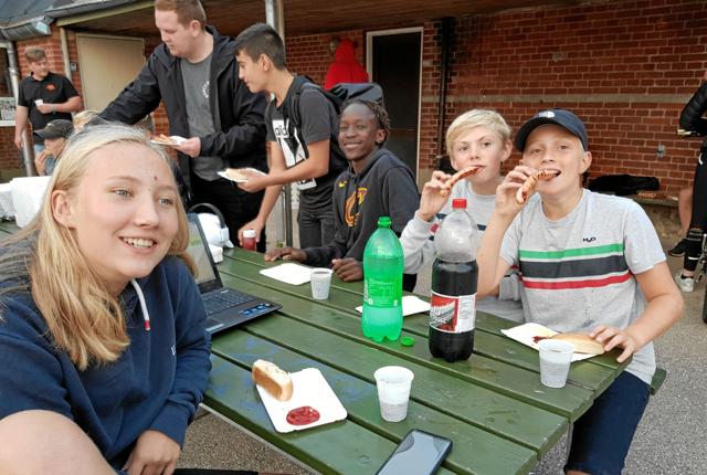 Julie, Kasper, Tobias, Kouic, Marin og Claus spiser grillpølser til klubstart til Assens ungdomsklub. 

Foto: Nanna Wagner sørensen.