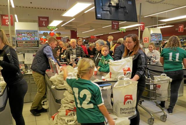 SuperBrugsen Løkken får hjælp fra spillere fra GVL til at pakke kundernes varer i poser. Foto: Arkivfoto