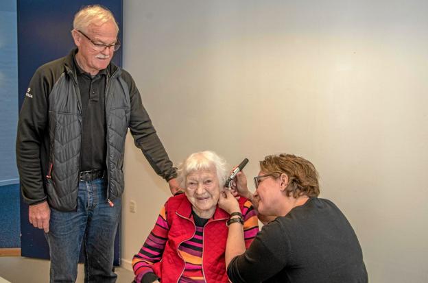 96 årige Gerda Andersen havde taget sin søn Finn med til høreprøven på Løgstør Parkhotel. Her ses Hanne undersøge Gerda med sønnen Finn stående. Foto: Mogens Lynge