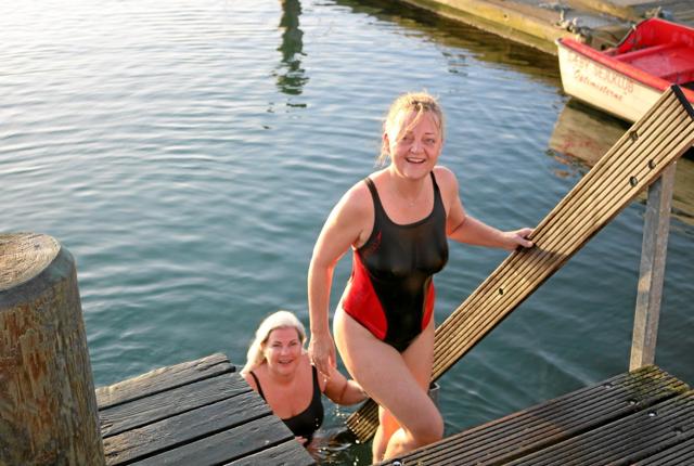 Morgenfriske Tina Christensen og Trine Dyg kan stadig smile efter en tur i det halvkolde vand. Foto: Tommy Thomsen