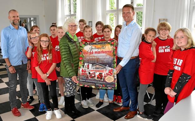 Viceforstander på Julemærkehjemmet, Klaus Rasmussen, underdirektør i Jutlander Bank, Carsten Brandt Andersen og Jytte Frederiksen, Fyrkatspillet, fotograferet i forbindelse med afsløringen af årets Julespilsplakat. Privatfoto