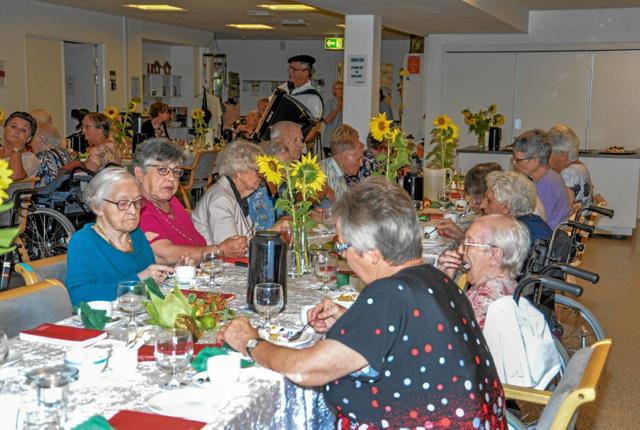 Flot pyntede borde med store solsikker gjorde lokalet festligt. Foto: Mogens Lynge