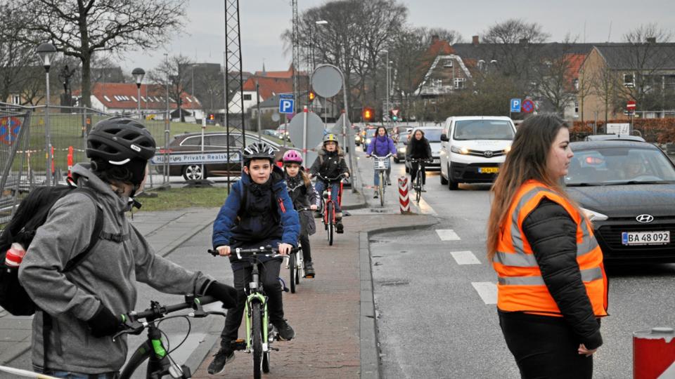 Biler, cyklister og fodgængere i stort tal færdes på Skolevangen om morgenen - og frivillige medlemmer fra Nemezis sørger for at passe på skolebørnene. 