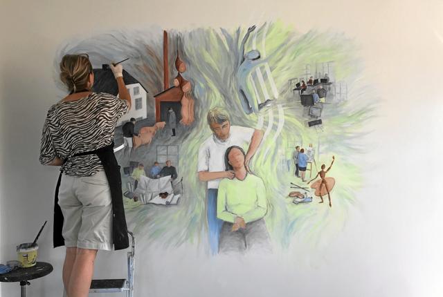 Billedkunstneren Kiss Jönsson er ved at lægge de sidste strøg på det store vægmaleri, hos Mariagerfjord Kiropraktorernes klinik i Hadsund. Privatfoto