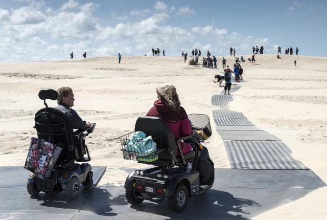 Kørestolsbrugere får snart mulighed for at komme helt til tops på Råbjereg Mile. Og da sandet opfører sig som vinden blæser skal der fejes, og det gør heller ikke noget, at man har en hjælper med.Arkivfoto: Peter Broen
