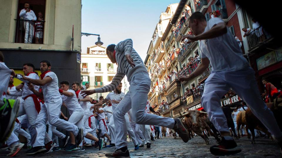 Folk løber foran tyre i det berømte og berygtede løb i Spanien. <i>Miguel Riopa/Ritzau Scanpix</i>