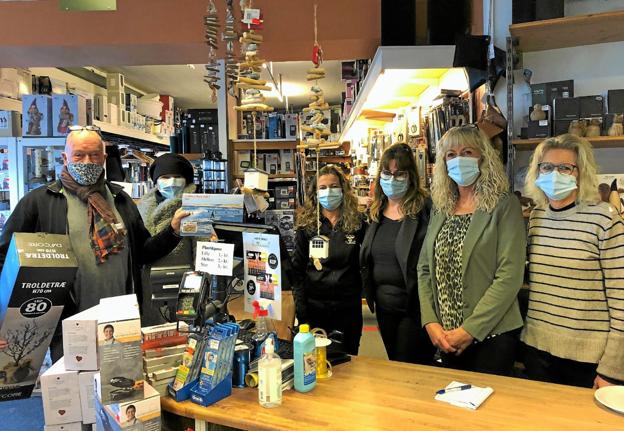 Fra venstre er det to af butikkens faste kunder og bag disken Dorthe Bjerg, Helle Larsen, Lene Bast Nielsen og Vita Tolstrup. Alle kunder fik Kop & Kandes nye kalender med billeder af nedenstående fotograf. - Vi smiler bag mundbindene, lyder den muntre kommentar. Foto: Kirsten Olsen