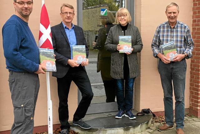 Martin Eigenbroth, til venstre, har overrakt de første eksemplarer af Han Herred Bogen 2021 til fra venstre Otto Kjær Larsen, Bente Kristensen og Peter Eigenbroth. Foto: Ida Mehl Agerholm