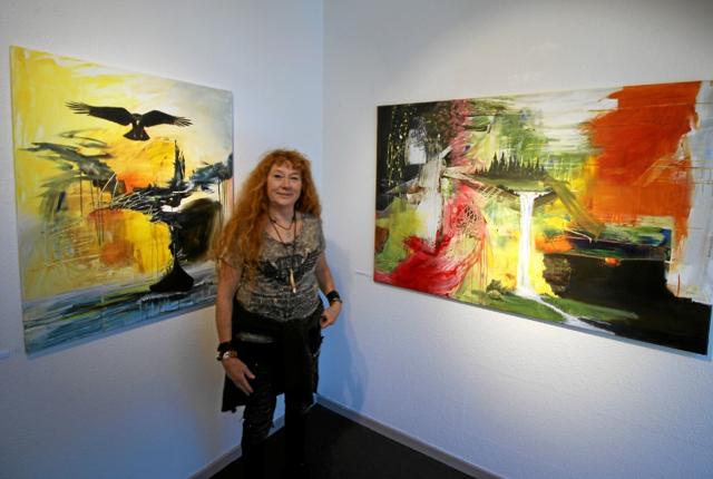 Louise Thygesen står her mellem to af sine værker på udstillingen. Hun maler acryl på lærred. Foto: Jørgen Ingvardsen
