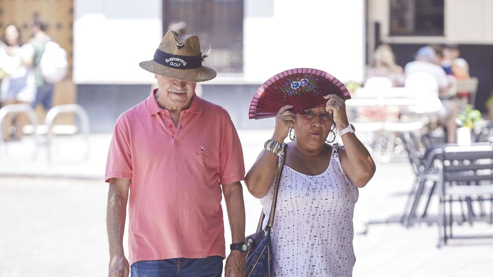 Hat og vifte tages i brug under hedebølgen i Sevilla, hvor temperaturerne har nået 43 grader. <i>Joaquin Corchero/Ritzau Scanpix</i>