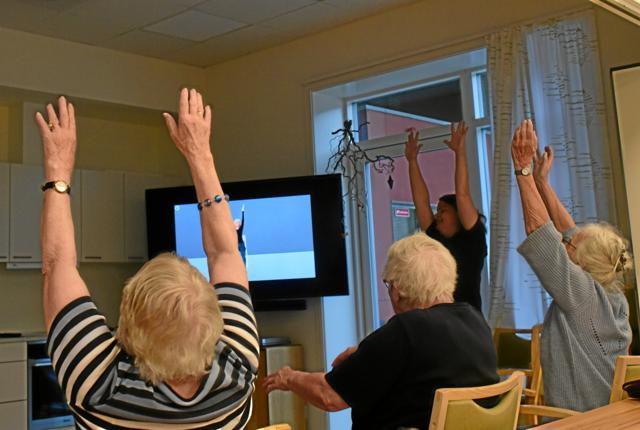 En flok beboere på Brovst Friplejehjem testede søndag træningsprogrammet Seniorform foran skærmen sammen med social- og sundhedsassistent Tanja Wendel (i baggrunden t.h.). Privatfoto
