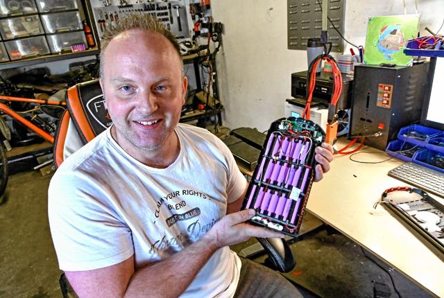 Tony Christensen skifter de flade batterier på elcyklen med nye kraftigere batteri-celler. Det er billigere og bæredygtigt.