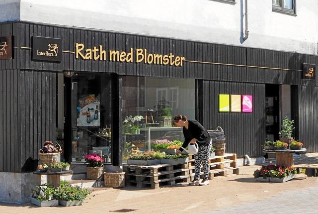 Rath med Blomster har udvidet forretningen med en døgnåben blomsterautomat med indgang fra Fredensgade. Indgangen er til højre for Louise Jensen, der nusser og passer blomsterne uden for butikken. Foto: Niels Helver