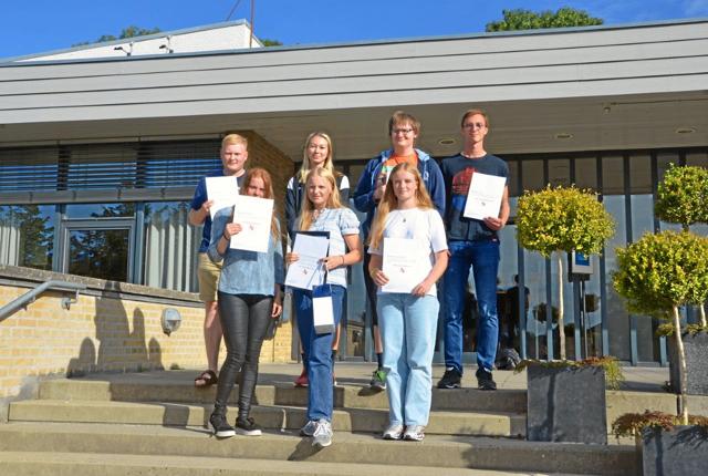 Syv af årets legatmodtagere fotograferet på trappen foran Mariagerfjord Gymnasium.  ?Privatfoto
