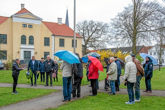 En lille, sluttet skare var mødt op i anlægget ved den gamle politistation for at deltage i kransenedlæggelsen ved Ove Andersens mindesten. Foto: Mogens Lynge