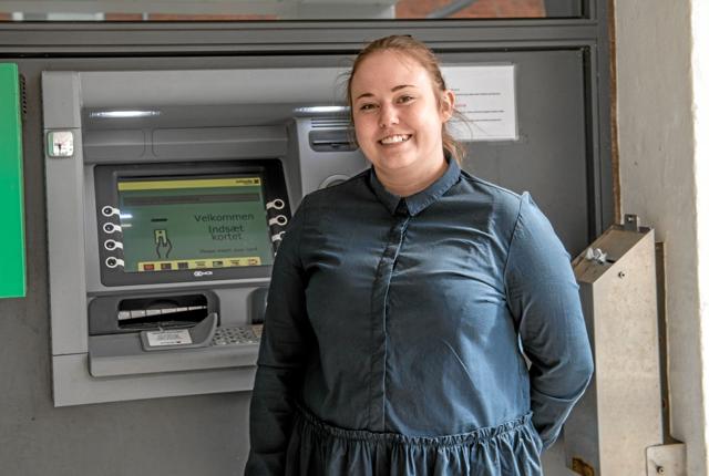 Her er det kundemedarbejder Kamilla Krogh fra Jutlander Bank Løgstør der står ved siden af den beskadigede pengeautomat. Bemærk den beskadigede indbetalingsluge nederst tv. Foto: Mogens Lynge
