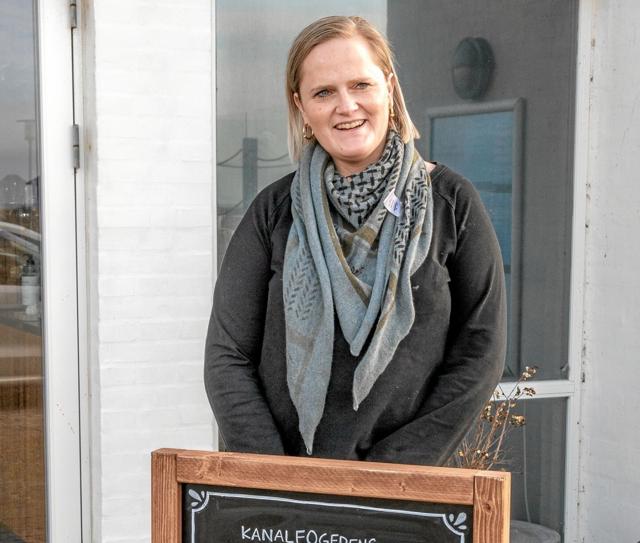 Karen Skovbøll Jensen ved skiltet med ”Kanalfogedens Lette”, d.v.s. små hjemmelavede tilbud, som kan nydes i naturen på stedet eller tages med hjem. Foto: Mogens Lynge