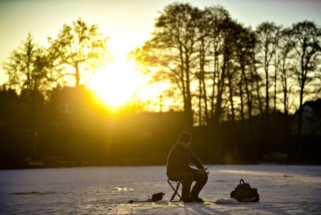 Peter Franke var kørt helt fra Auning på Djursland for at indløse fiskekort til isfiskeri på Snæbum Sø, mens både børn og voksne stod på skøjter omkring ham. Foto: Claus Søndberg