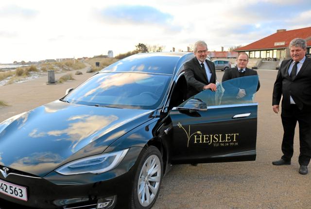 Frank Hejslet, Brian Høgh og John Hejslet ved begravelsesforretningens nye miljøvenlige Tesla rustvogn, der er den første af sin art i Danmark. Foto: Tommy Thomsen