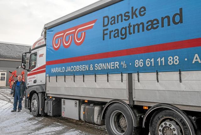 Chauffør Peter Knudsgaard foran den lastbil, som i det daglige bringer ham rundt med gods og pakker. Foto: Mogens Lynge