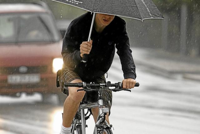 Antallet af cyklister, der er snuppet for at køre med en håndholdt telefon er næsten firdoblet - mens der ikke foreligger nogen statistik over antallet af cyklister, der kører med håndhold paraply, som tilfældet er her. Arkivfoto