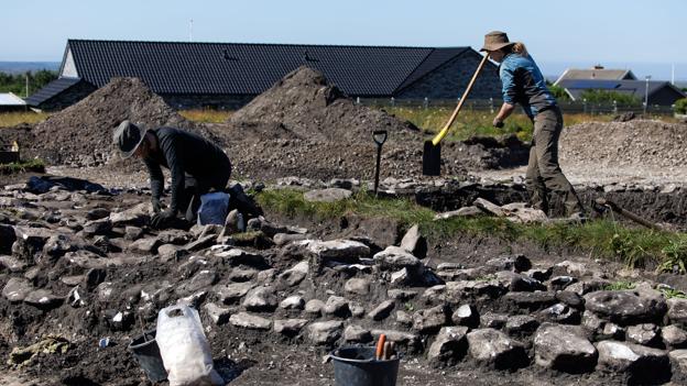 Arkæologerne Astrid Roborg Hammelsvang, th. og Kirstine Krath Helweg, arbejder på at udgrave to af gravene i højen, centralgraven og en senere begravelse i stensætningen. <i>Foto: Bo Lehm</i>