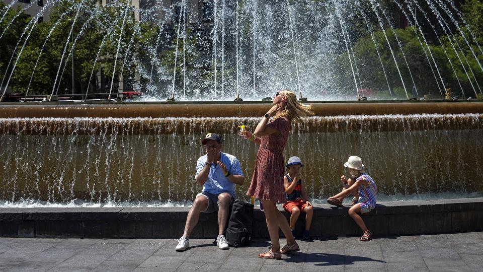 En familie køler ned ved et springvand i den spanske storby Barcelona, mens de påfører et ekstra lag solcreme. Den varme, der i noget tid har præget Sydeuropa, kommer nu også længere nordpå til blandt andet Tyskland og Storbritannien. <i>Emilio Morenatti/Ritzau Scanpix</i>
