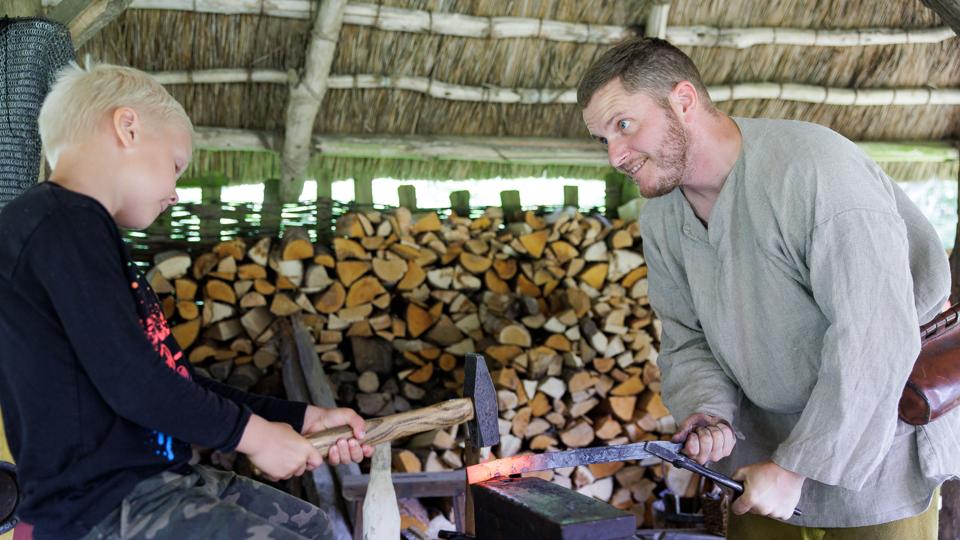 Sofus fra Hillerslev hjælper museumsformidler Rune Kjeldager Tjørnild med at smede til Jernalderdage på Heltborg Museum. <i>Foto: Bo Lehm</i>